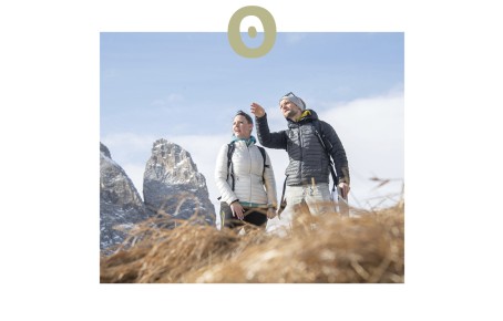 Das Bild zeigt Paul Felix Rigo in den Dolomiten. Er zeigt senem Coachee, einer Frau, gerade die Berge.