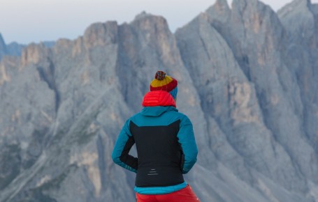 rigofree | professionelle Coachings Outdoor in den Dolomiten Südtirols zu jeder Jahreszeit und zu fast jedem Wetter Das Bild zeigt Paul Felix Rigo beim Betrachten der wunderbaren Dolomitenfelsen. Er trägt wärmende und sportliche Kleidung, weil es am Berg und in der Höhe nicht gerade warm ist.